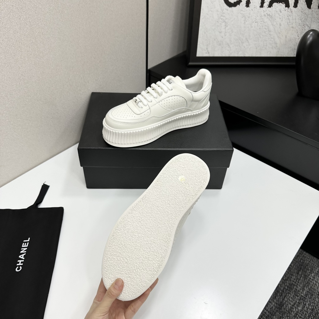 Pair of white Chanel leather platform sneakers with interlocking CC logo on the side, displayed on a black luxury box. - Hình 4