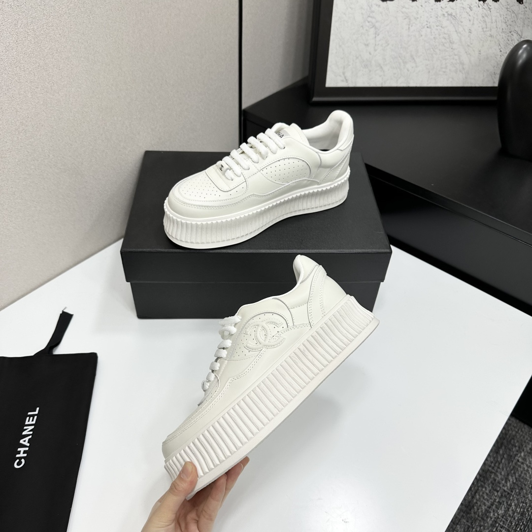 Pair of white Chanel leather platform sneakers with interlocking CC logo on the side, displayed on a black luxury box. - Hình 3