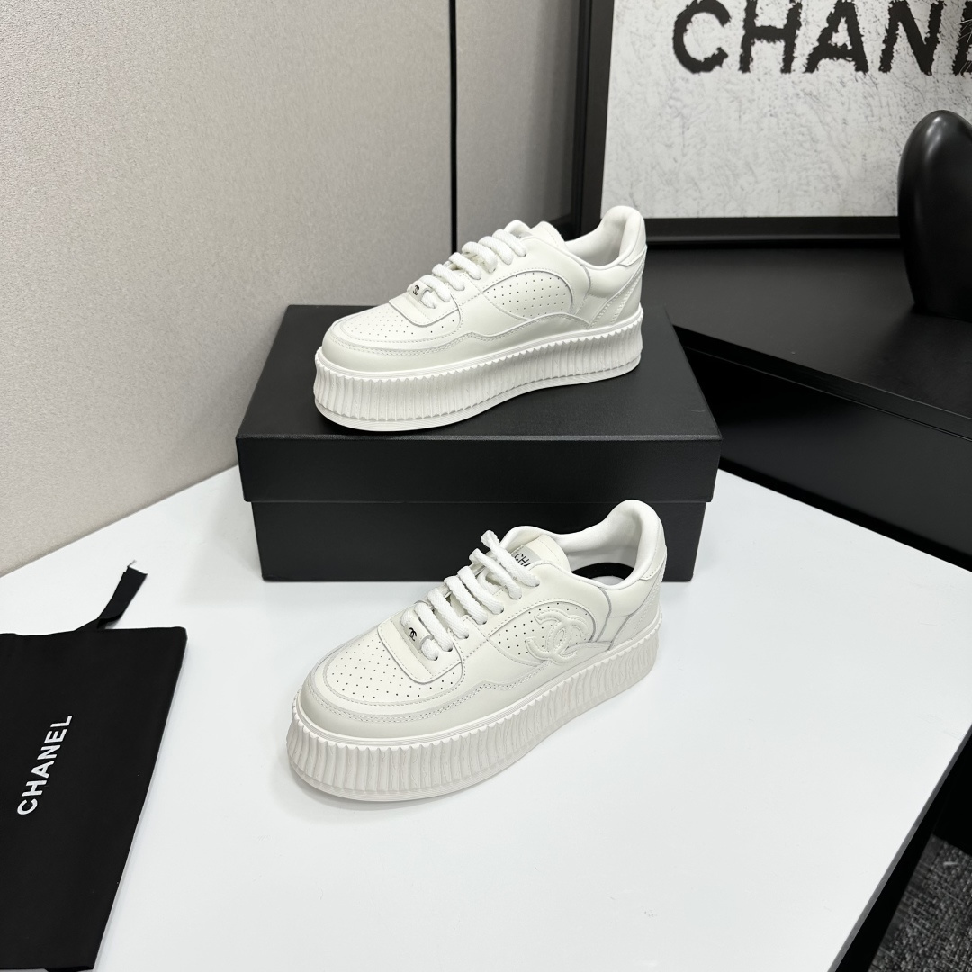 Pair of white Chanel leather platform sneakers with interlocking CC logo on the side, displayed on a black luxury box. - Hình 2