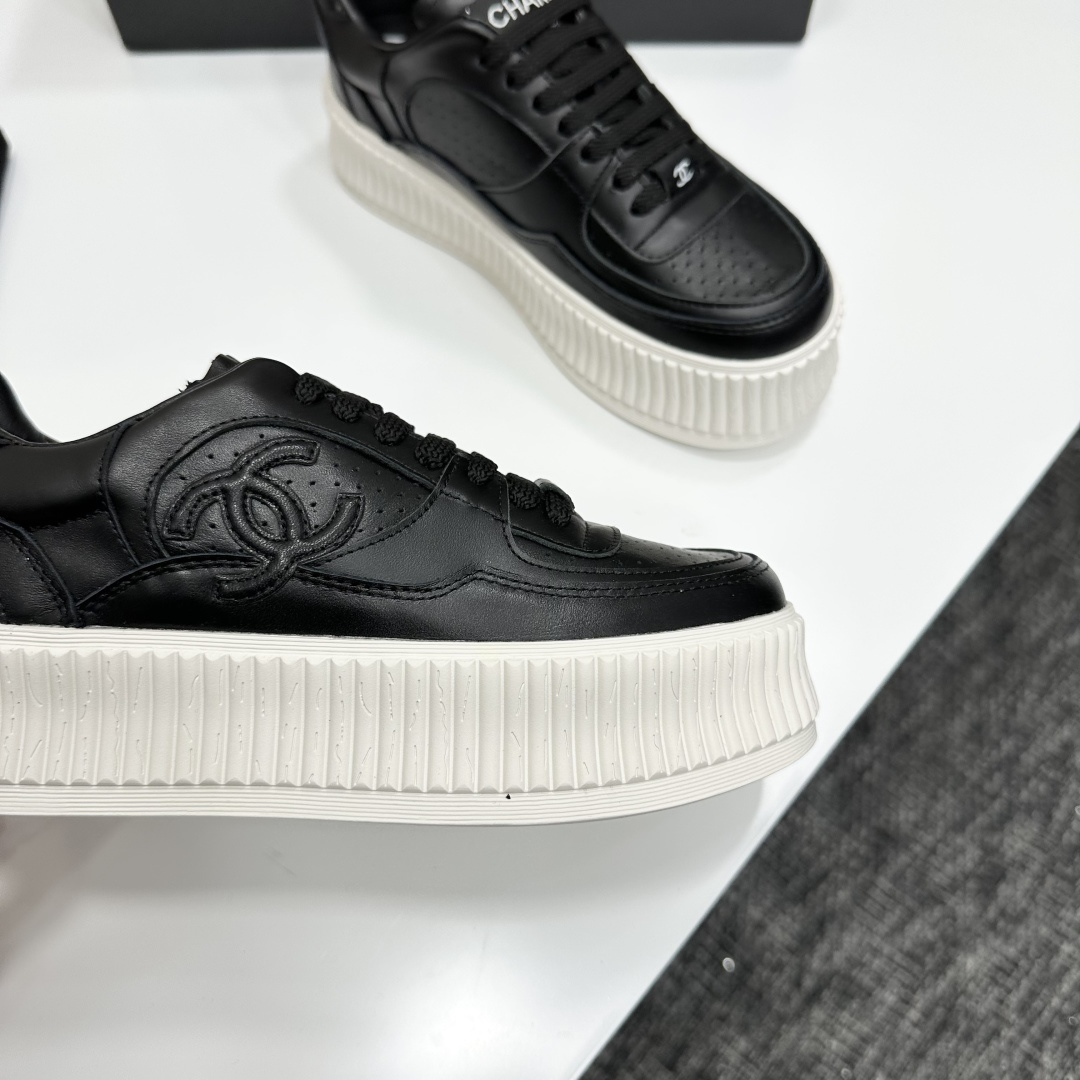 Luxury Chanel black leather platform sneakers with embossed CC logo and chunky white ribbed sole on a display box. - Hình 9