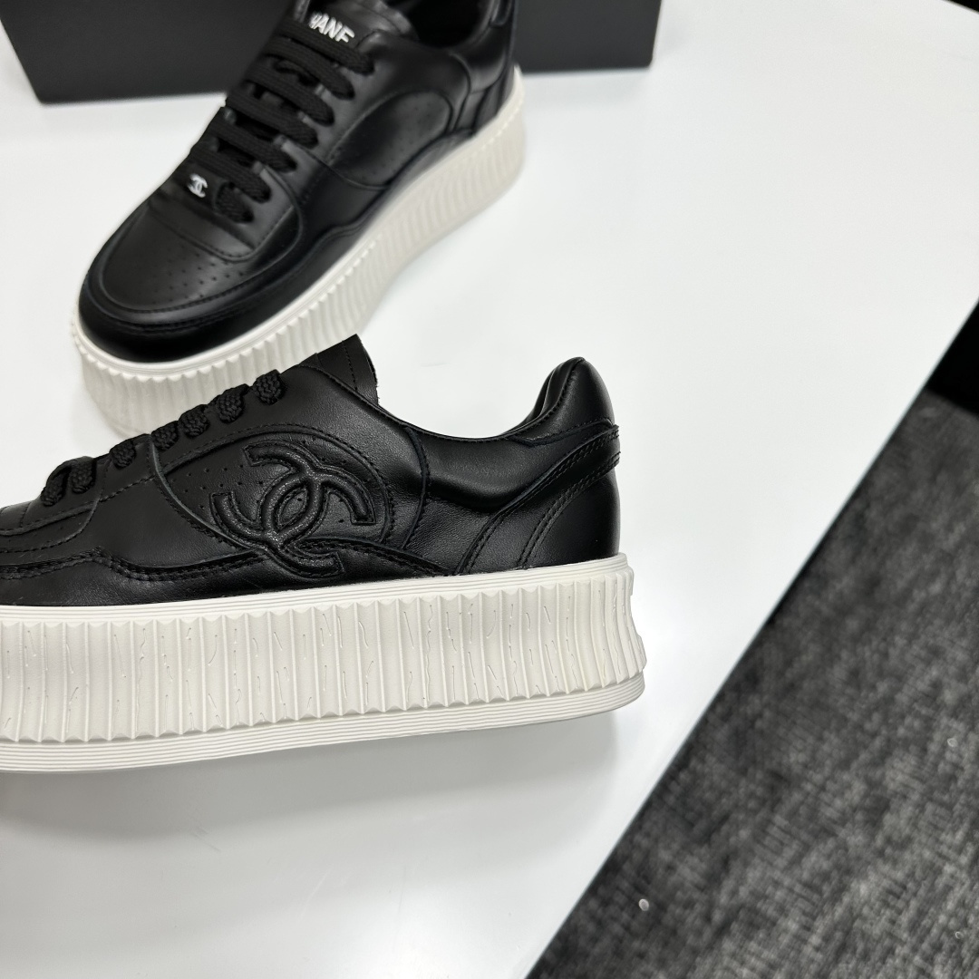 Luxury Chanel black leather platform sneakers with embossed CC logo and chunky white ribbed sole on a display box. - Hình 6