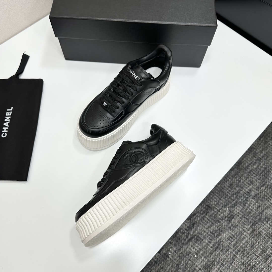 Luxury Chanel black leather platform sneakers with embossed CC logo and chunky white ribbed sole on a display box. - Hình 5