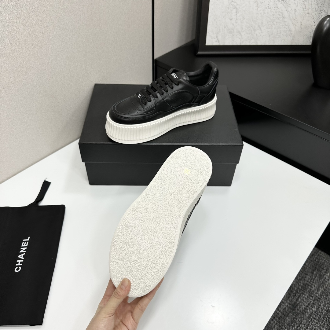 Luxury Chanel black leather platform sneakers with embossed CC logo and chunky white ribbed sole on a display box. - Hình 4