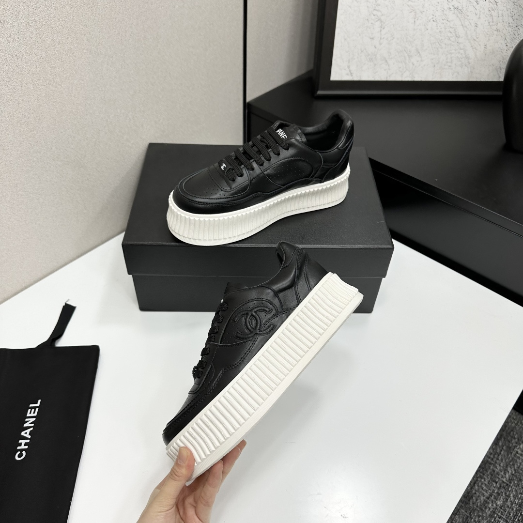 Luxury Chanel black leather platform sneakers with embossed CC logo and chunky white ribbed sole on a display box. - Hình 3