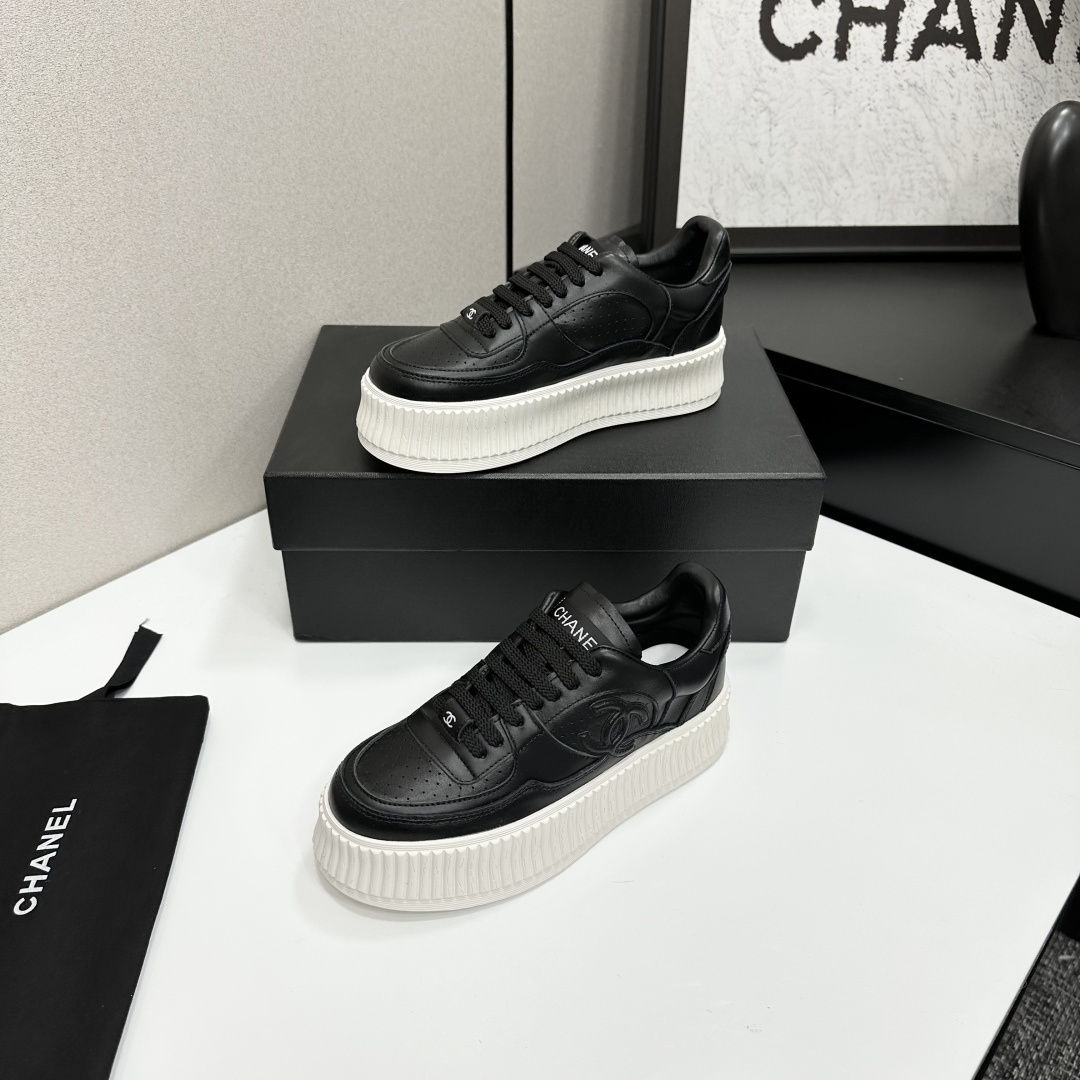 Luxury Chanel black leather platform sneakers with embossed CC logo and chunky white ribbed sole on a display box. - Hình 2
