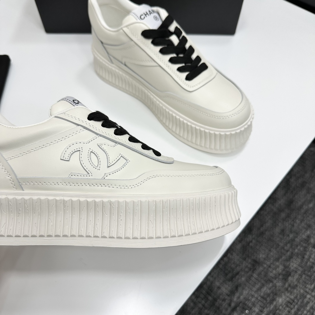 A pair of Chanel white leather platform sneakers with black laces and the iconic CC logo on the side. - Hình 8
