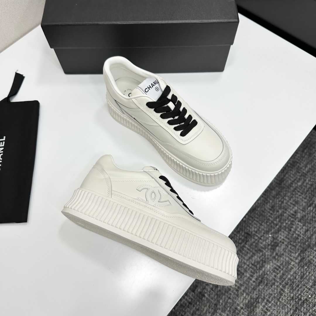 A pair of Chanel white leather platform sneakers with black laces and the iconic CC logo on the side. - Hình 7