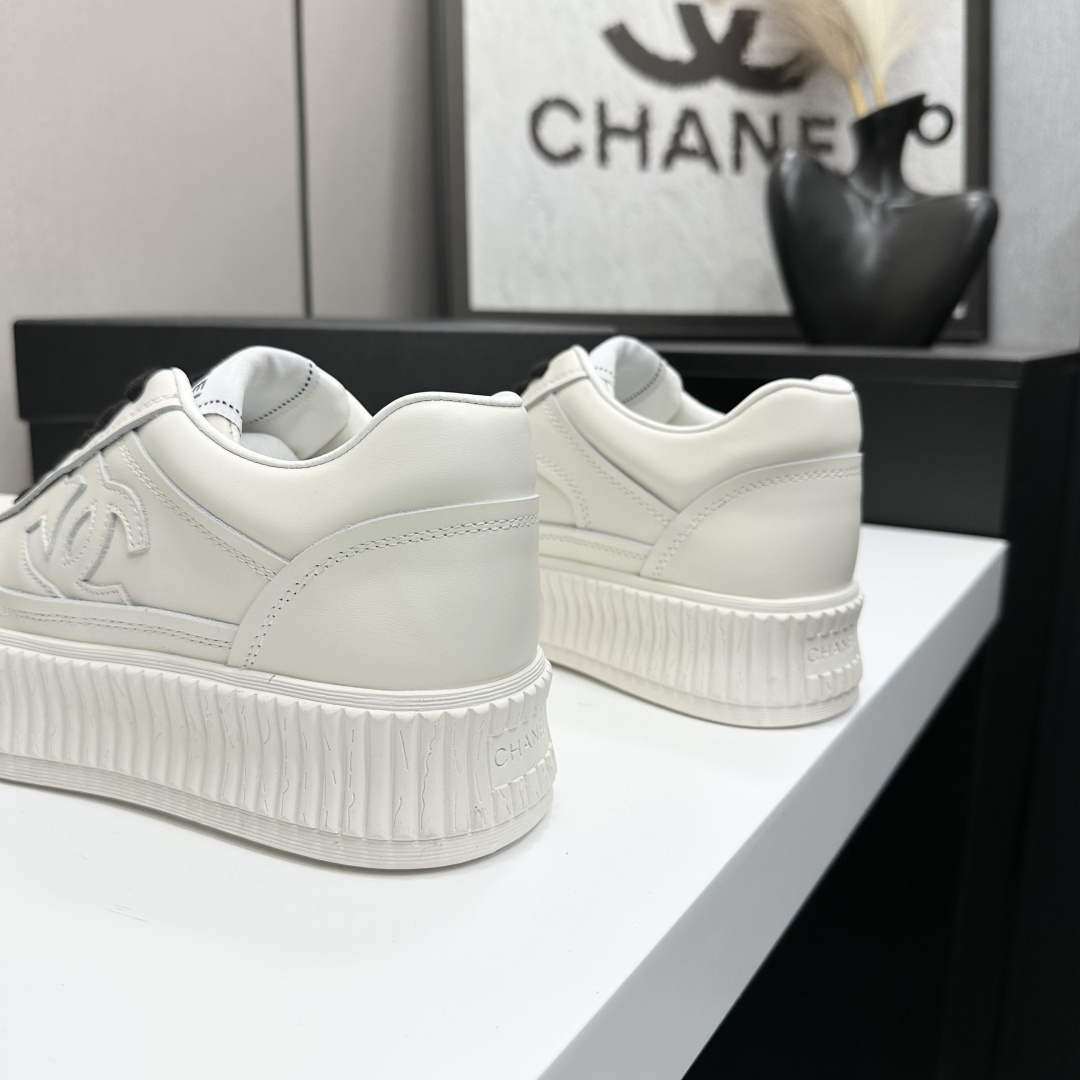 A pair of Chanel white leather platform sneakers with black laces and the iconic CC logo on the side. - Hình 6