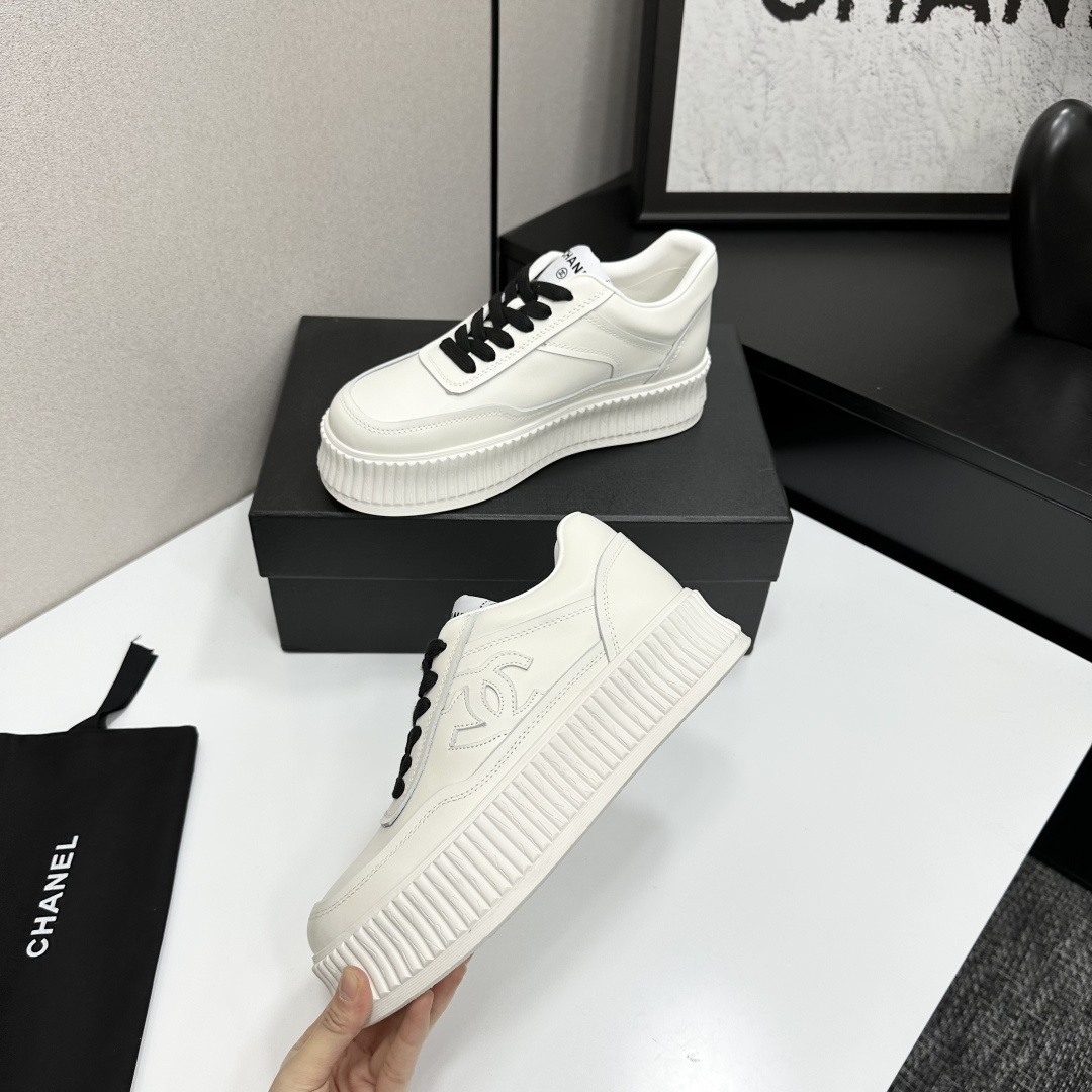 A pair of Chanel white leather platform sneakers with black laces and the iconic CC logo on the side. - Hình 3