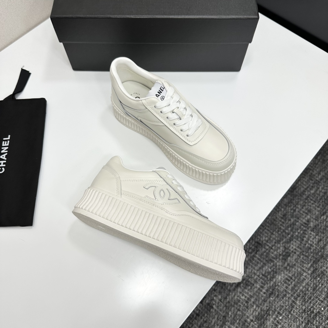 A pair of Chanel white leather platform sneakers with interlocking CC logo displayed on a black designer box. - Hình 9