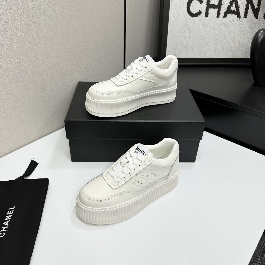 A pair of Chanel white leather platform sneakers with interlocking CC logo displayed on a black designer box. - Hình 3