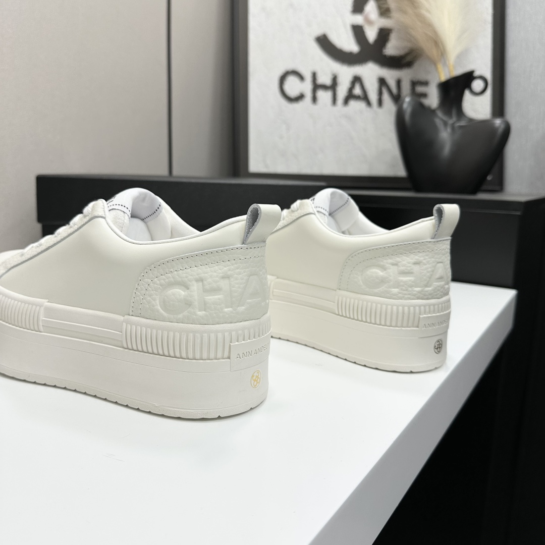 A pair of luxury Chanel white leather platform sneakers with chunky ribbed soles on a black display box. - Hình 5