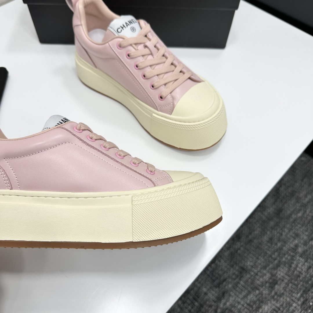 A pair of luxury Chanel pink leather sneakers with thick cream platform soles displayed on a black designer box. - Hình 8
