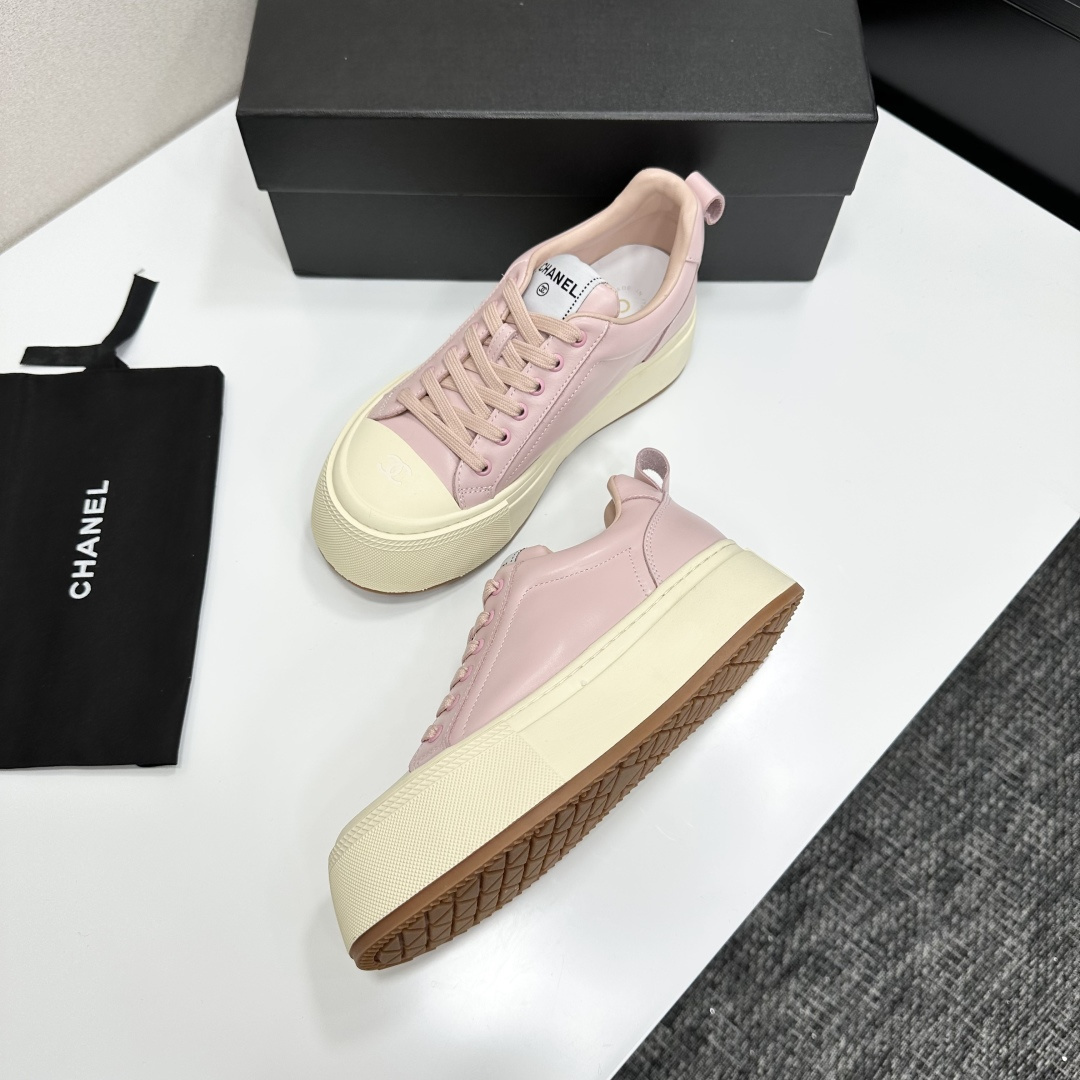 A pair of luxury Chanel pink leather sneakers with thick cream platform soles displayed on a black designer box. - Hình 5
