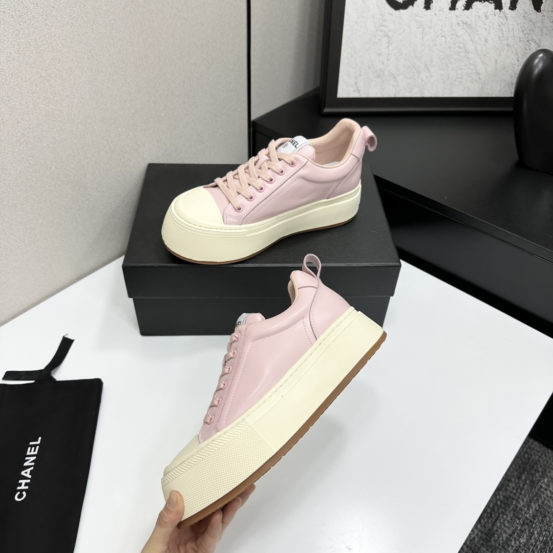 A pair of luxury Chanel pink leather sneakers with thick cream platform soles displayed on a black designer box. - Hình 3
