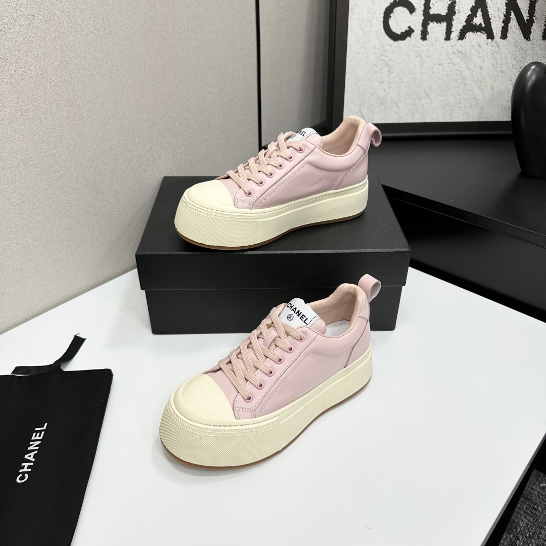 A pair of luxury Chanel pink leather sneakers with thick cream platform soles displayed on a black designer box. - Hình 2