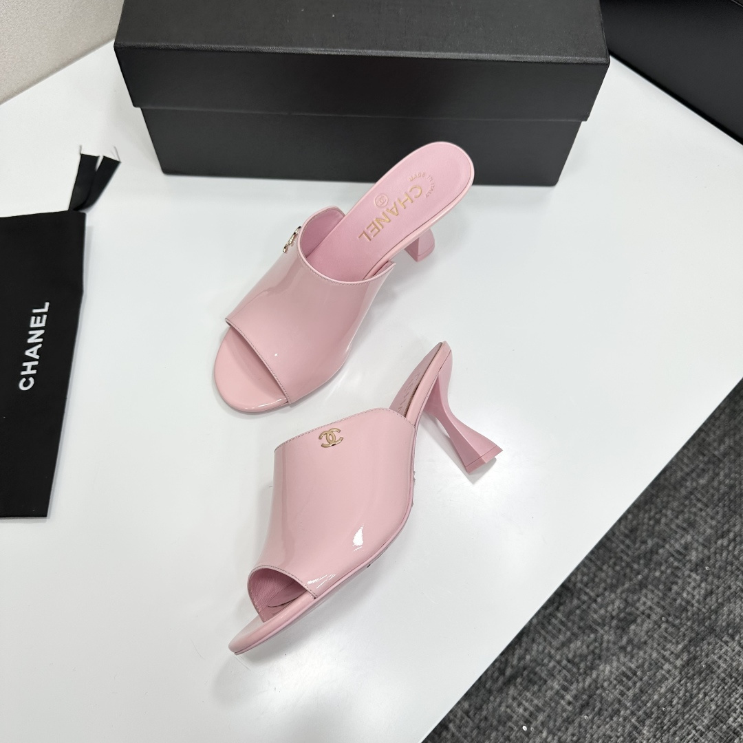 A pair of pink Chanel patent leather mules with gold CC logo and sculpted heels displayed on a black designer box. - Hình 6
