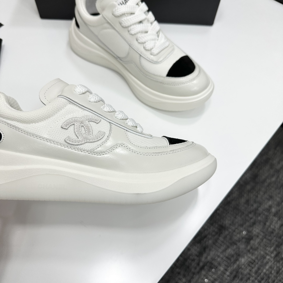 A pair of Chanel white mesh sneakers with black accents and a chunky white sole sitting on a black designer box. - Hình 10