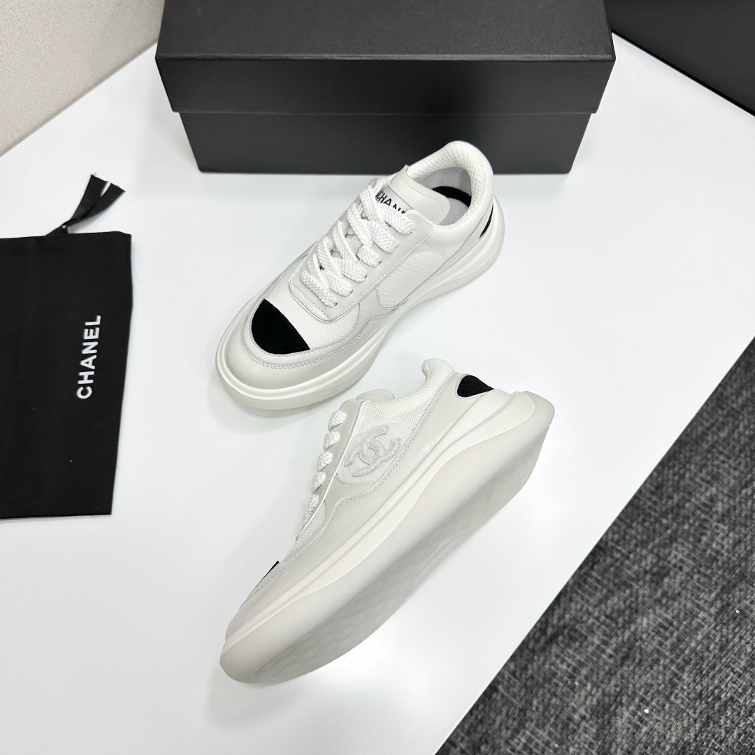 A pair of Chanel white mesh sneakers with black accents and a chunky white sole sitting on a black designer box. - Hình 6