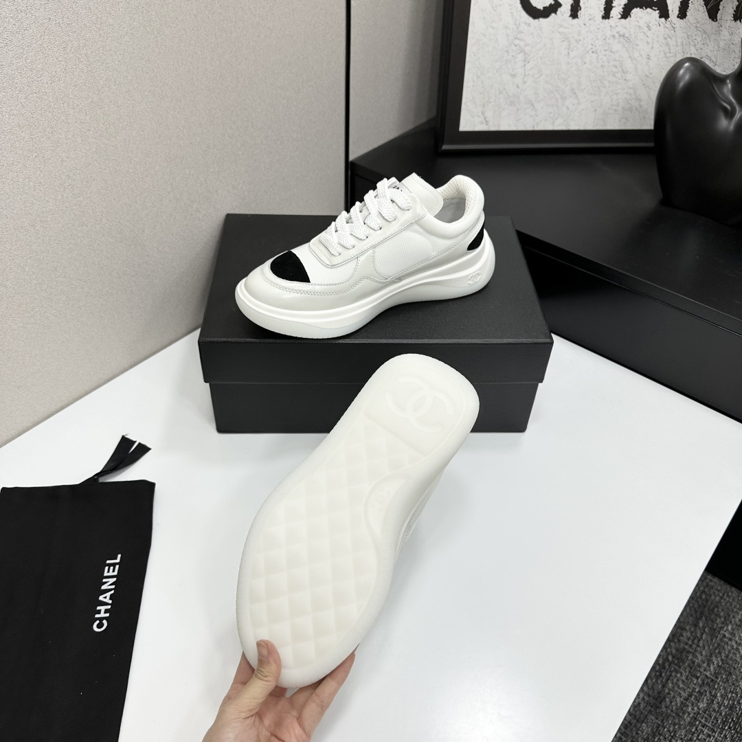 A pair of Chanel white mesh sneakers with black accents and a chunky white sole sitting on a black designer box. - Hình 5