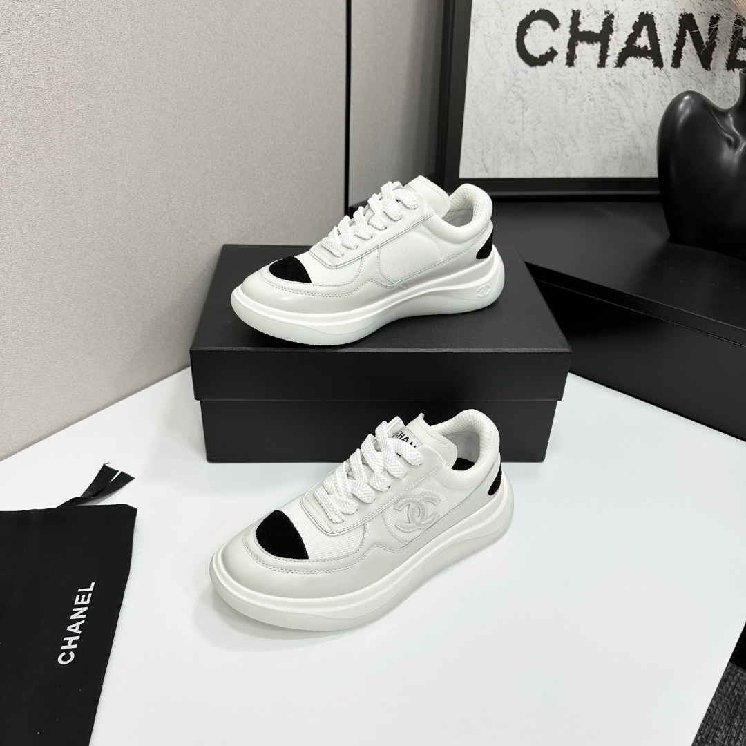 A pair of Chanel white mesh sneakers with black accents and a chunky white sole sitting on a black designer box. - Hình 3