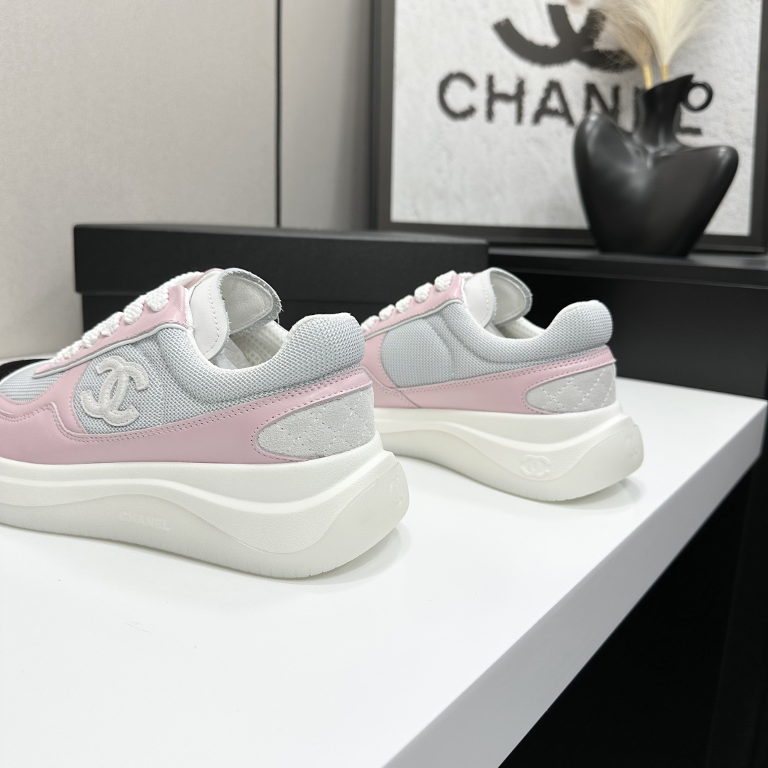 A pair of Chanel pink and grey mesh sneakers with a white platform sole and the CC logo, displayed on a black box. - Hình 8