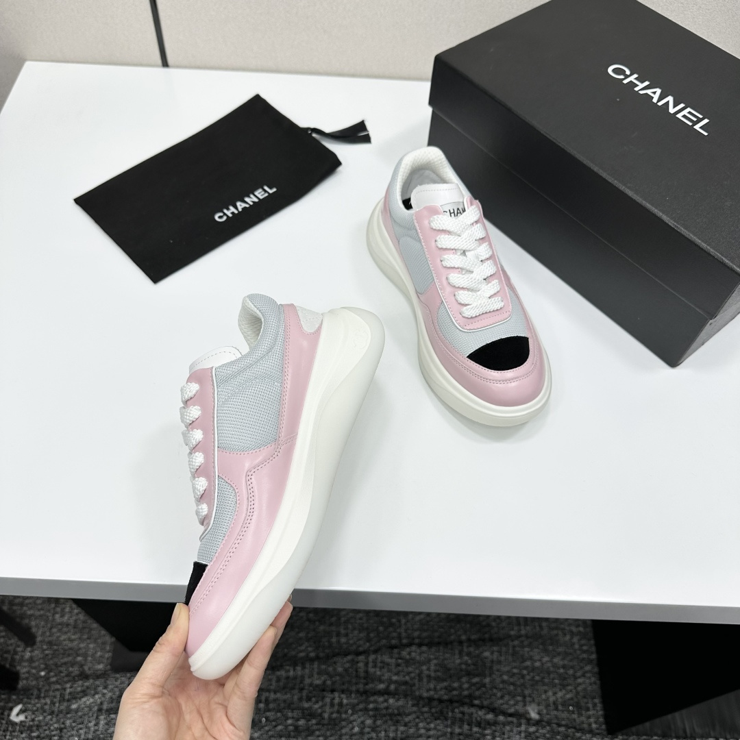 A pair of Chanel pink and grey mesh sneakers with a white platform sole and the CC logo, displayed on a black box. - Hình 2