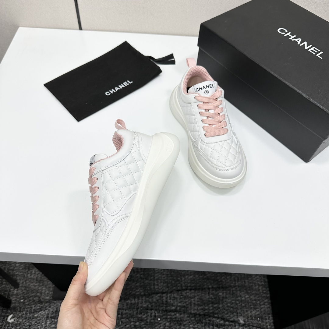 Chanel white quilted leather sneakers with pink laces and interlocking C logo on a black display box. - Hình 9