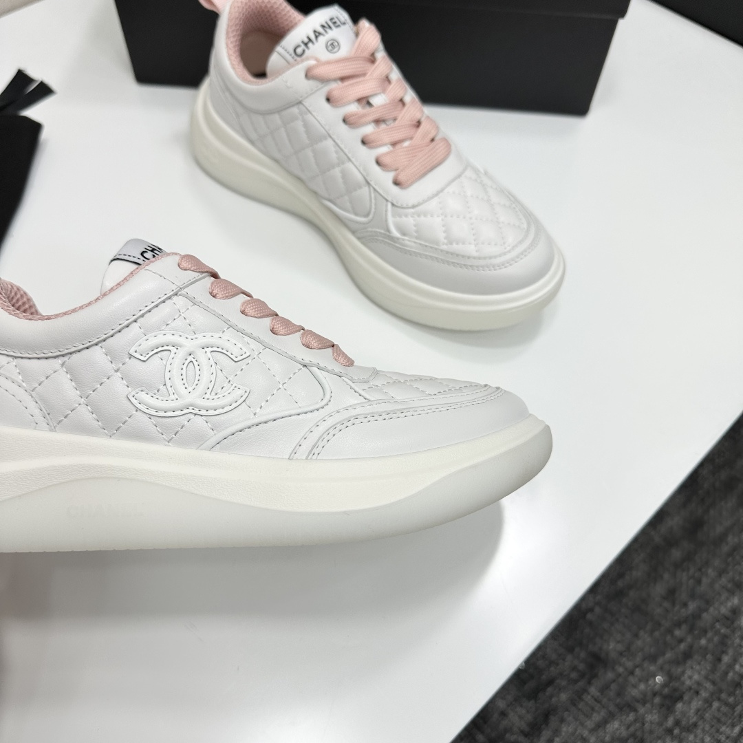 Chanel white quilted leather sneakers with pink laces and interlocking C logo on a black display box. - Hình 8