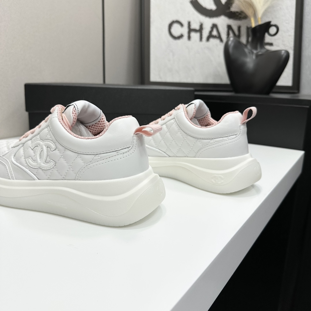 Chanel white quilted leather sneakers with pink laces and interlocking C logo on a black display box. - Hình 6