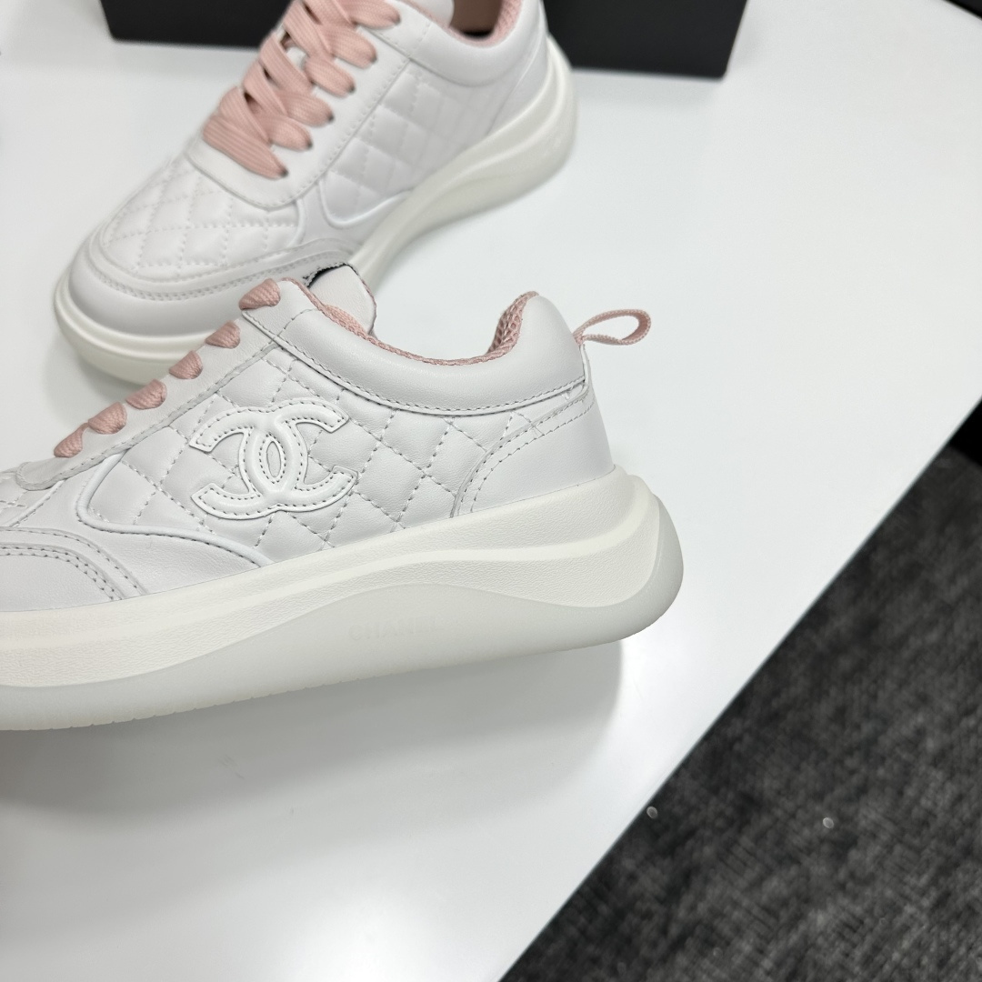 Chanel white quilted leather sneakers with pink laces and interlocking C logo on a black display box. - Hình 5