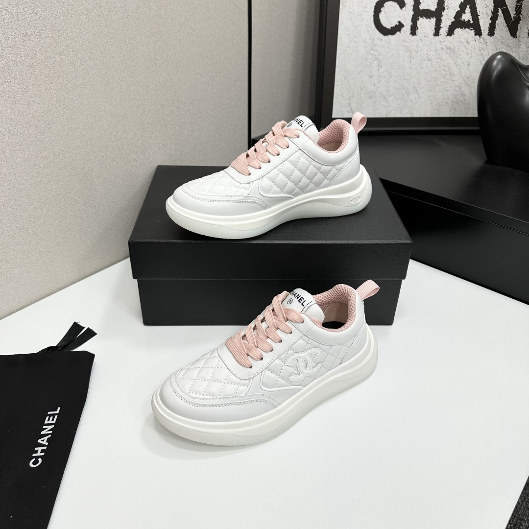 Chanel white quilted leather sneakers with pink laces and interlocking C logo on a black display box. - Hình 2
