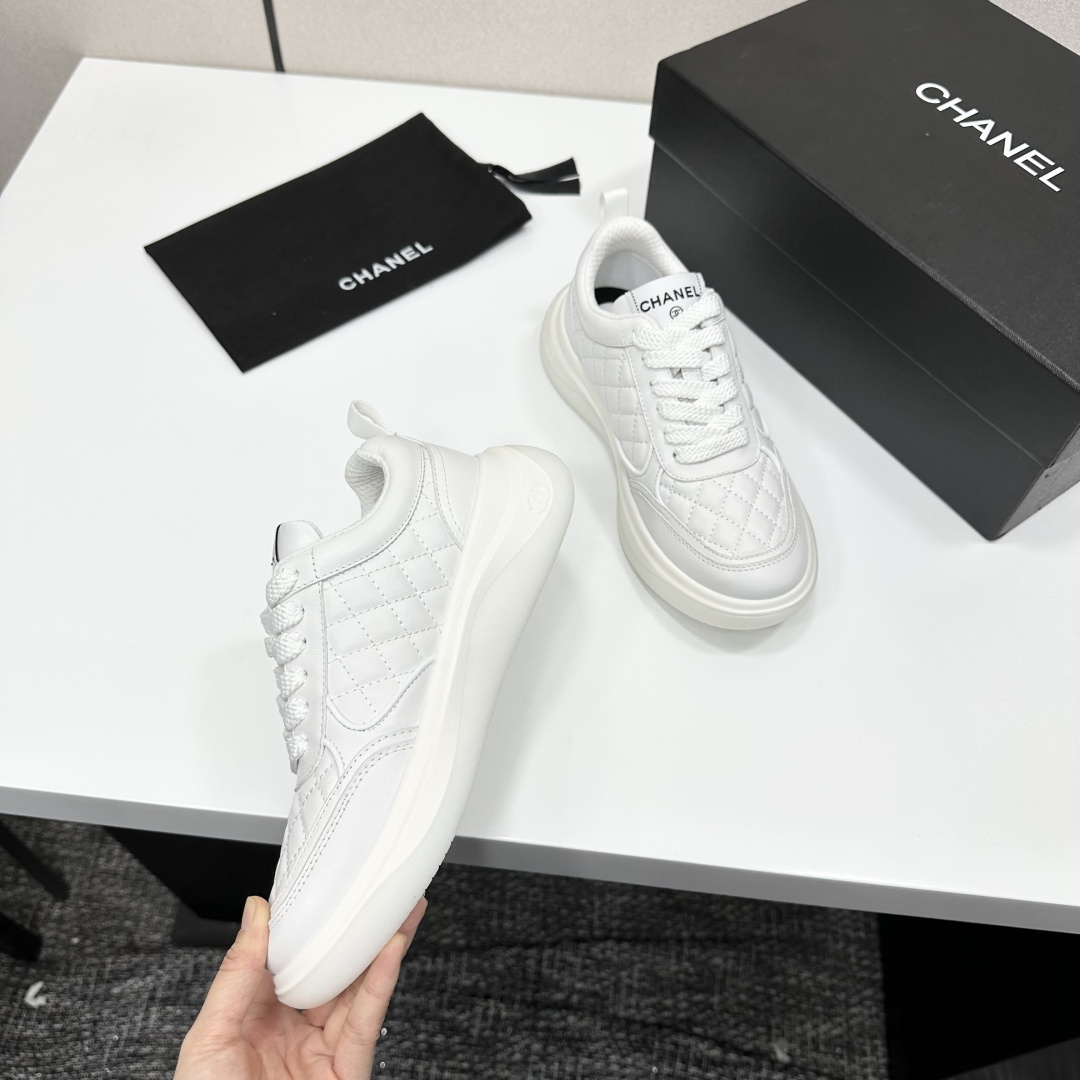 A pair of luxury white quilted leather sneakers with a thick platform sole and interlocking logo on a black display box. - Hình 9
