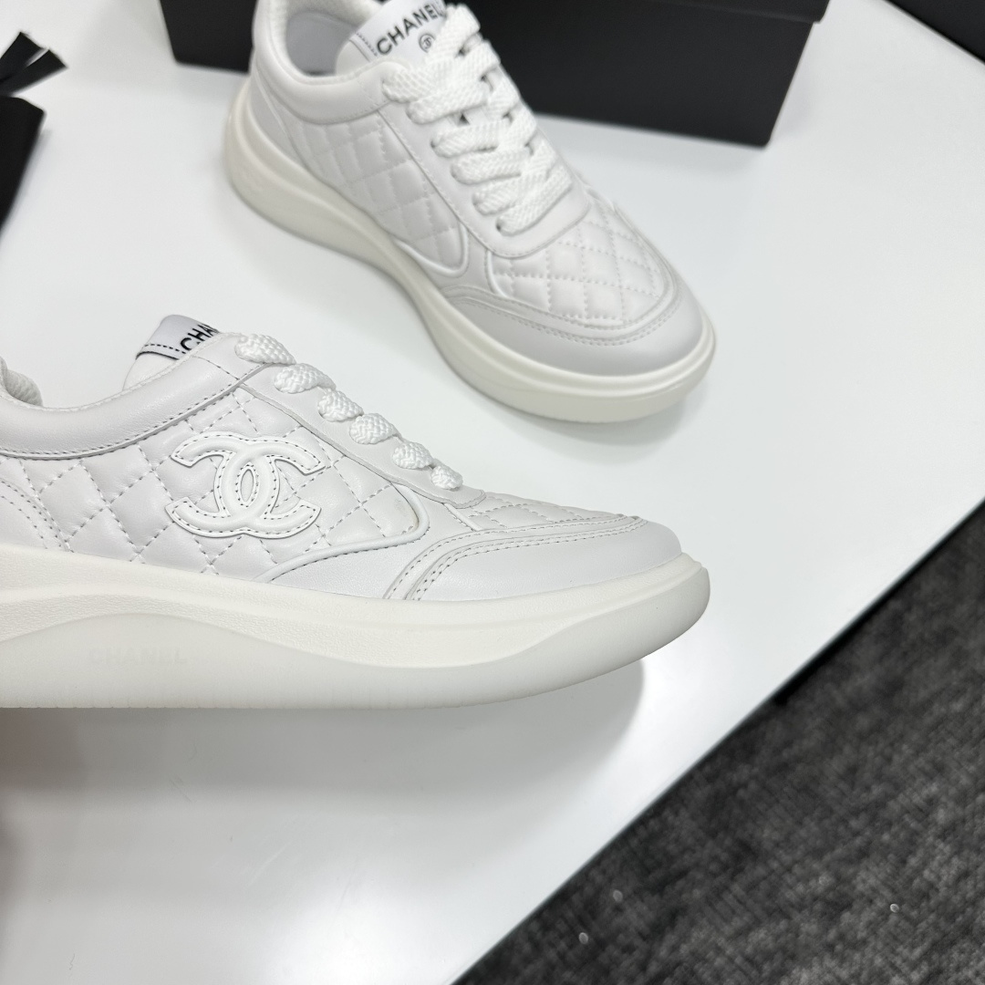 A pair of luxury white quilted leather sneakers with a thick platform sole and interlocking logo on a black display box. - Hình 2