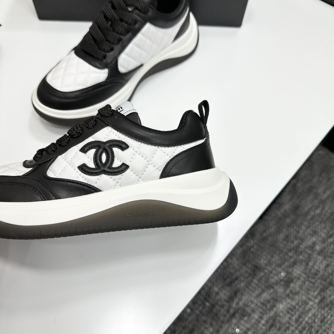 Pair of black and white Chanel quilted leather sneakers with CC logo on a black box - Hình 7