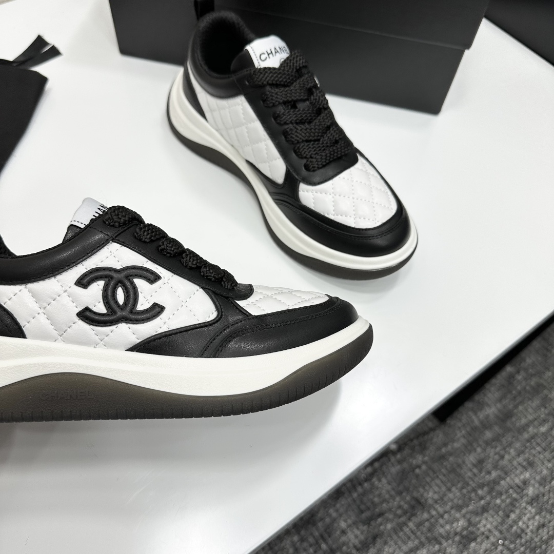 Pair of black and white Chanel quilted leather sneakers with CC logo on a black box - Hình 2