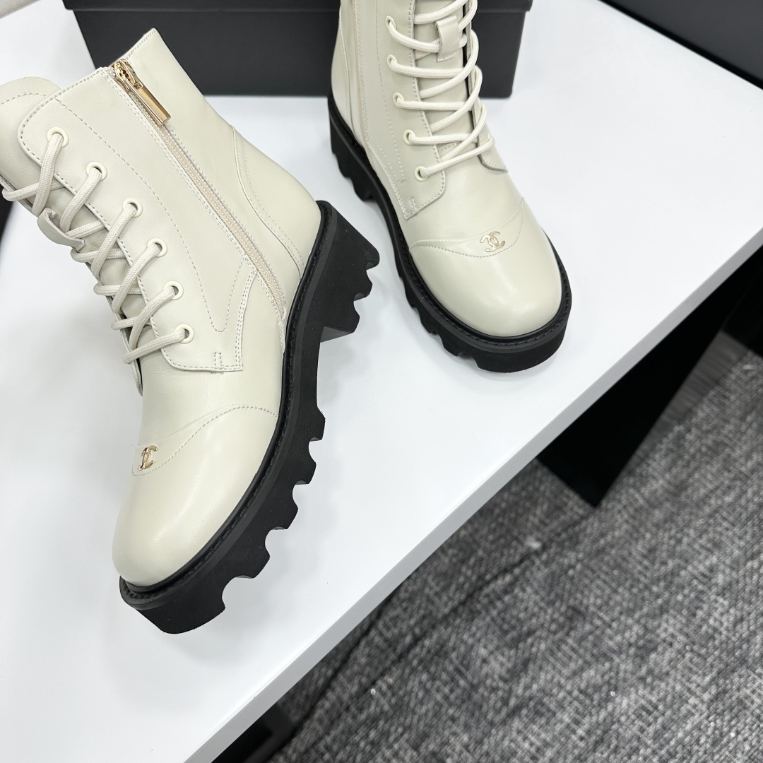 A pair of Chanel ivory leather lace-up combat boots with black chunky lug soles and gold CC logo on the toe cap. - Hình 9