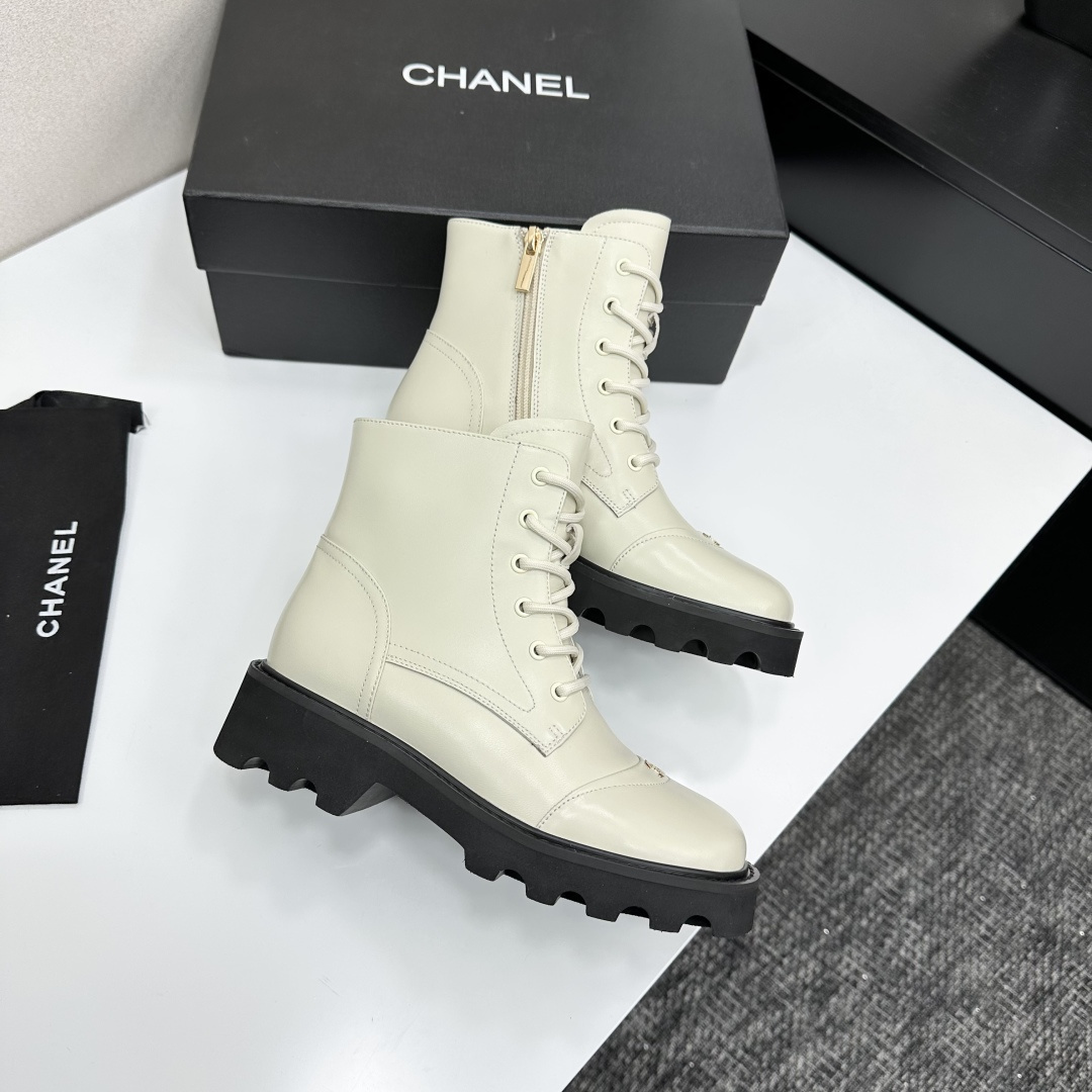 A pair of Chanel ivory leather lace-up combat boots with black chunky lug soles and gold CC logo on the toe cap. - Hình 8