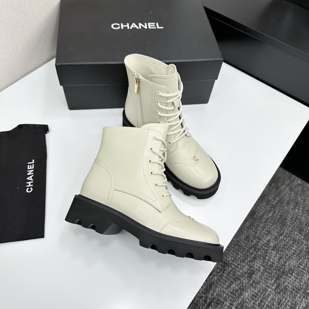 A pair of Chanel ivory leather lace-up combat boots with black chunky lug soles and gold CC logo on the toe cap. - Hình 7