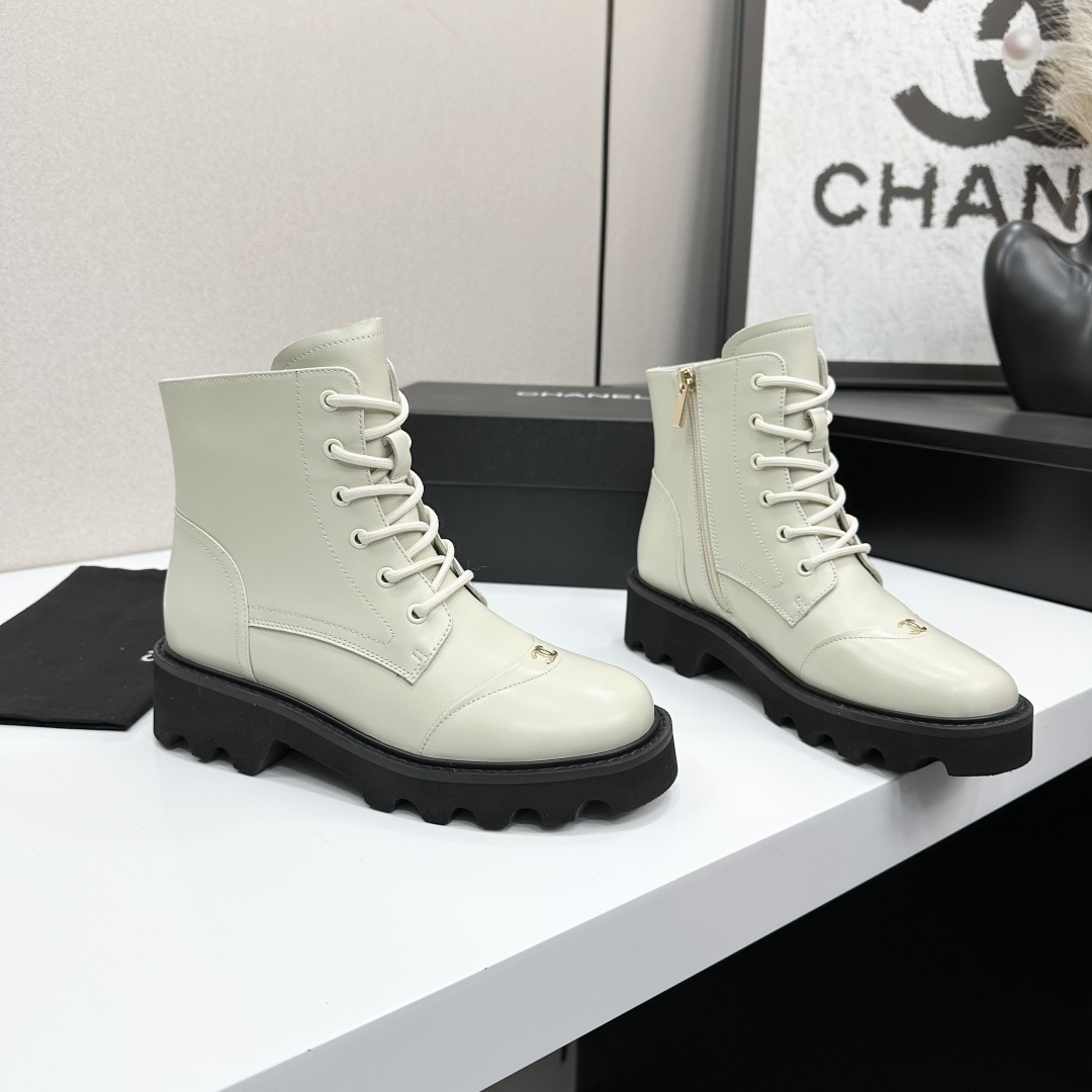 A pair of Chanel ivory leather lace-up combat boots with black chunky lug soles and gold CC logo on the toe cap. - Hình 6