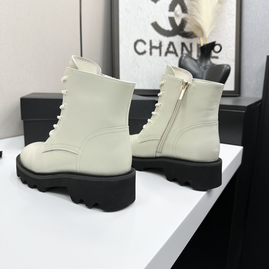 A pair of Chanel ivory leather lace-up combat boots with black chunky lug soles and gold CC logo on the toe cap. - Hình 5