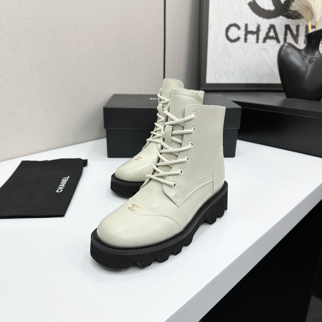 A pair of Chanel ivory leather lace-up combat boots with black chunky lug soles and gold CC logo on the toe cap. - Hình 4