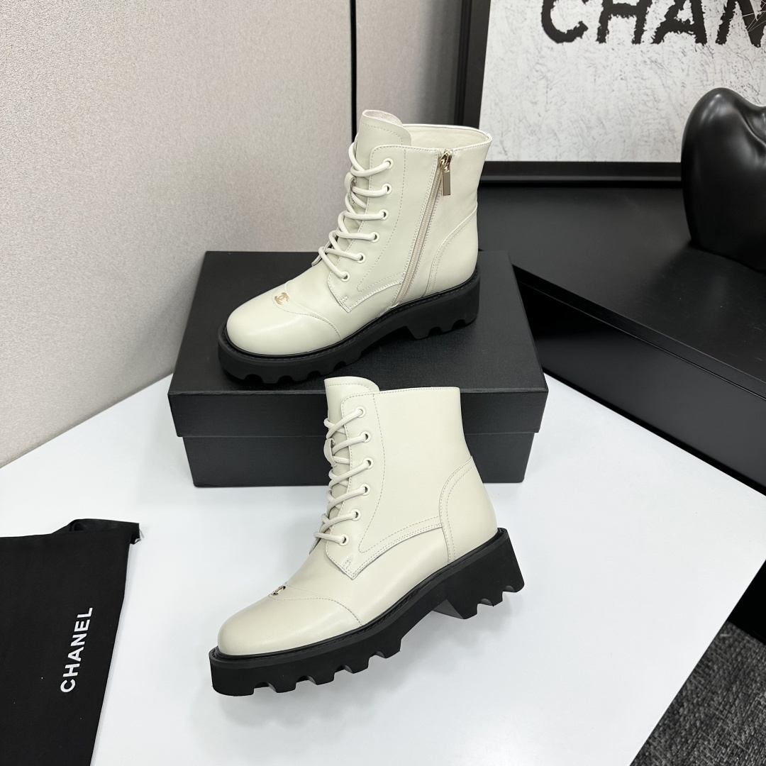 A pair of Chanel ivory leather lace-up combat boots with black chunky lug soles and gold CC logo on the toe cap. - Hình 3