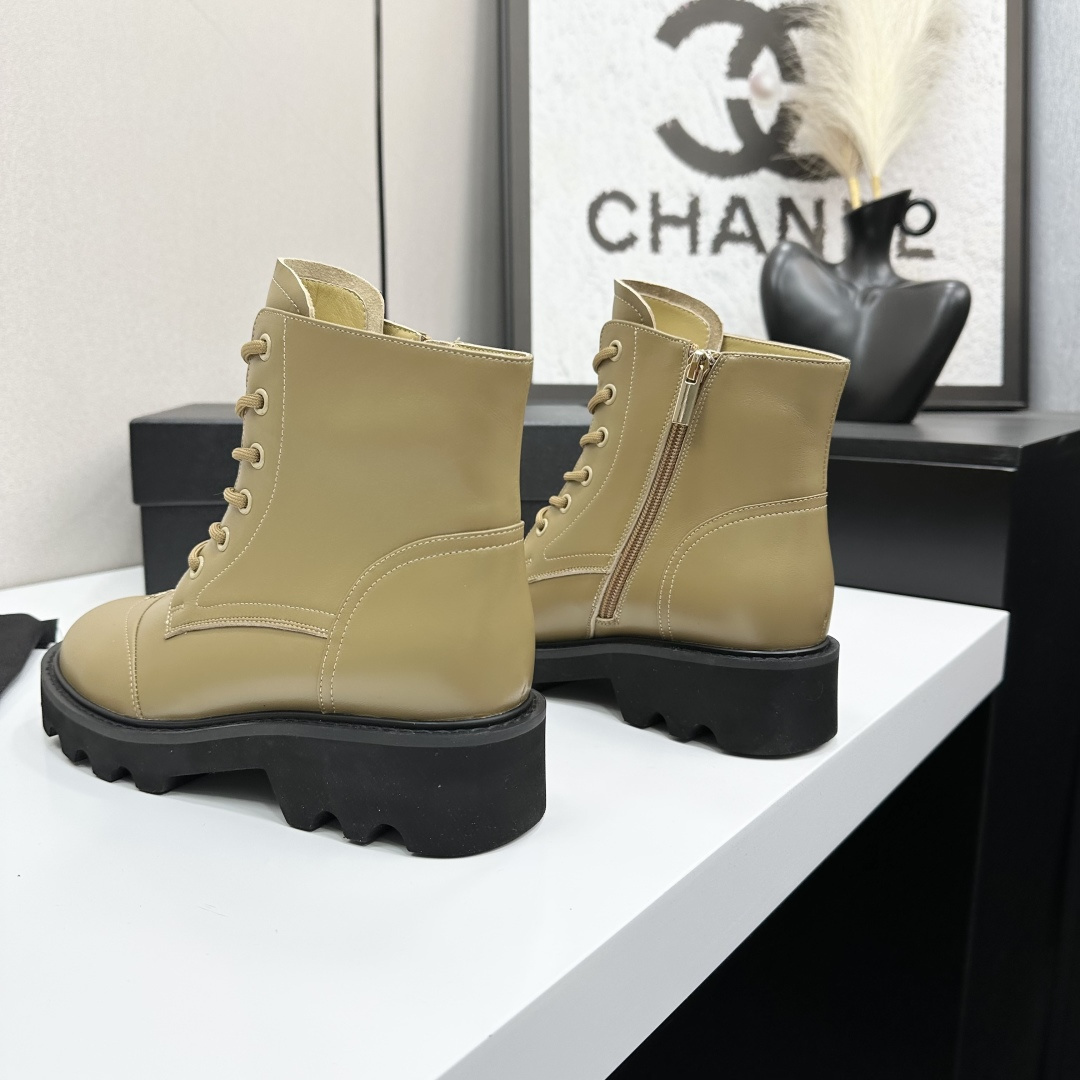 Pair of beige designer leather combat boots with chunky black soles and side zippers displayed on a black box. - Hình 5