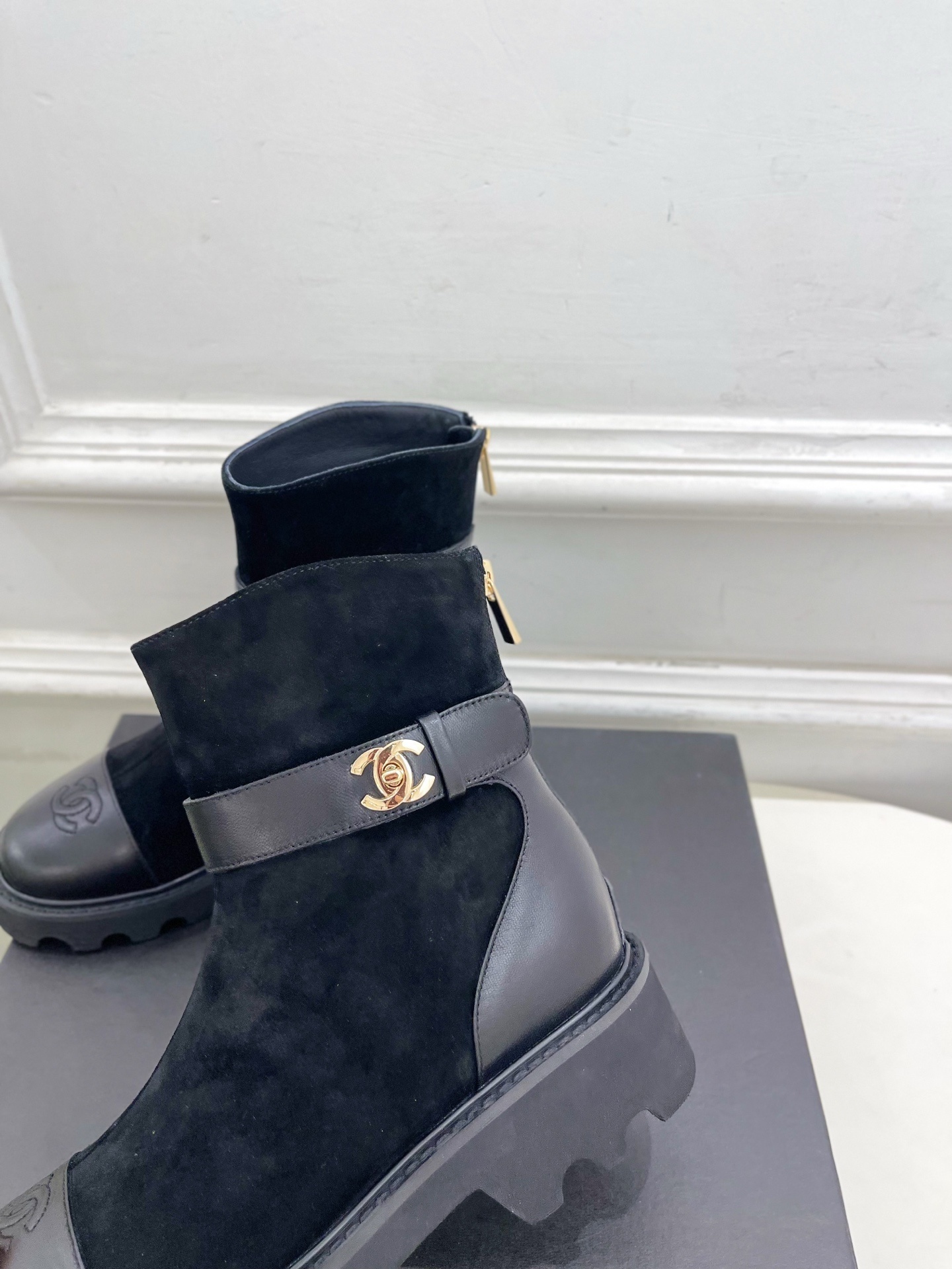 Chanel black suede and leather ankle boots with gold CC hardware and chunky soles displayed on a designer box - Hình 7