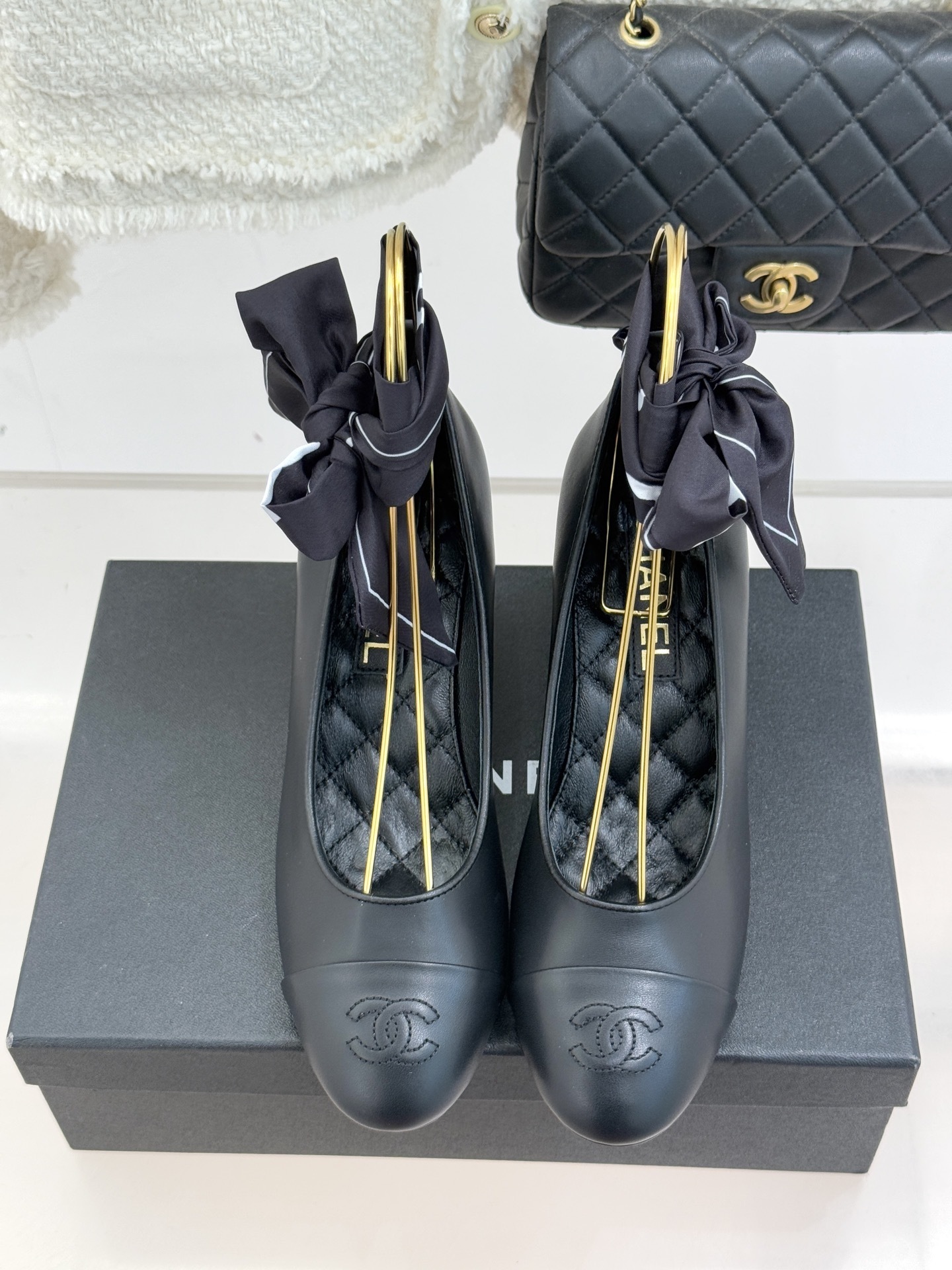 Pair of black Chanel leather pumps with white pearl spherical heels and black silk ribbons tied at the ankles. - Hình 4