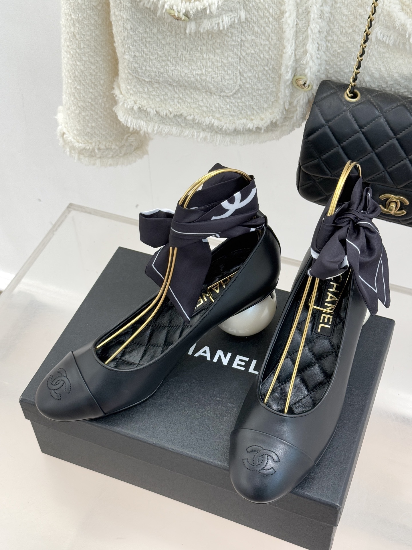 Pair of black Chanel leather pumps with white pearl spherical heels and black silk ribbons tied at the ankles. - Hình 2
