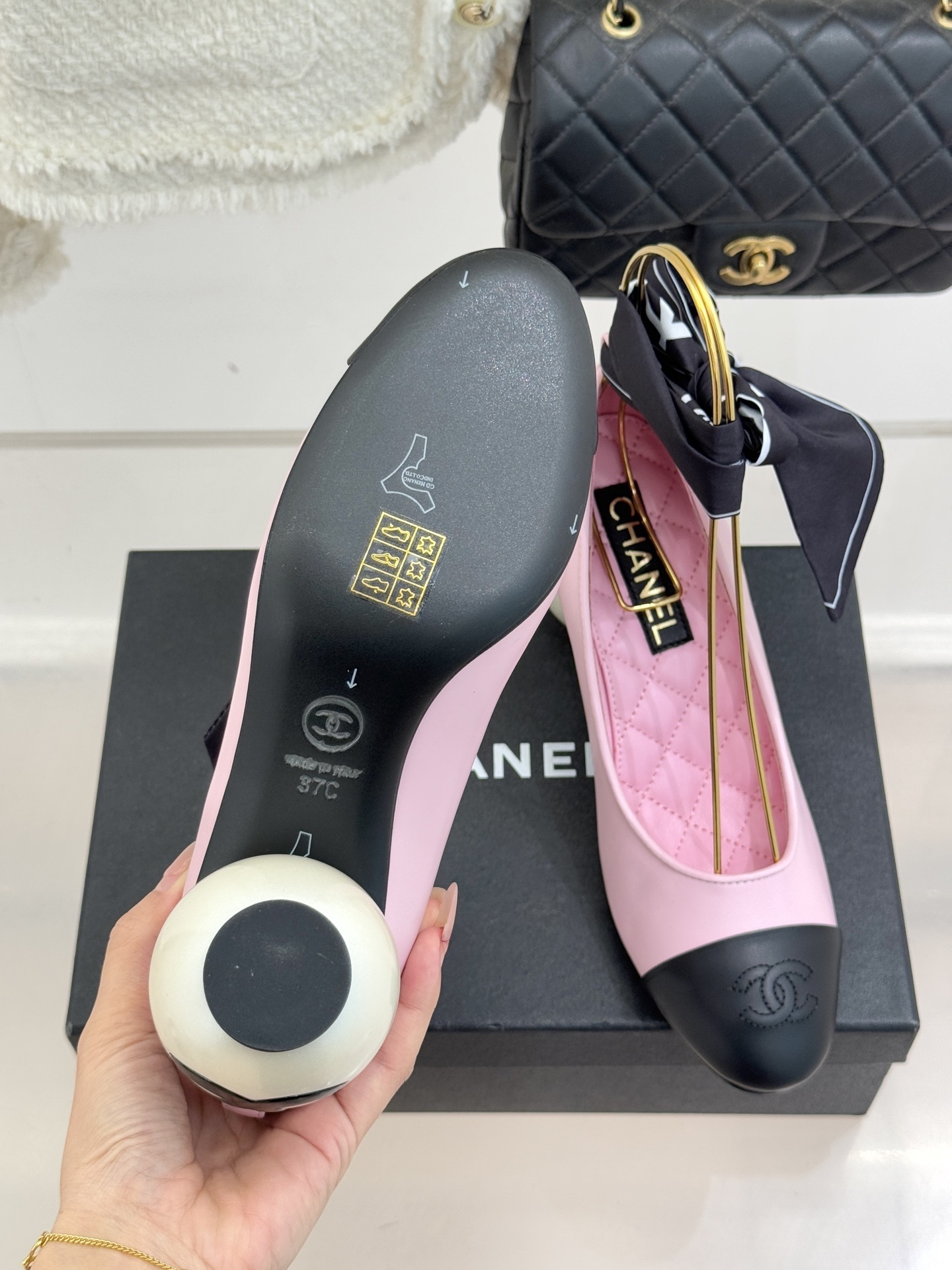 Chanel pink leather pumps with black cap toe and a large white pearl heel, featuring black bow accents on top. - Hình 9