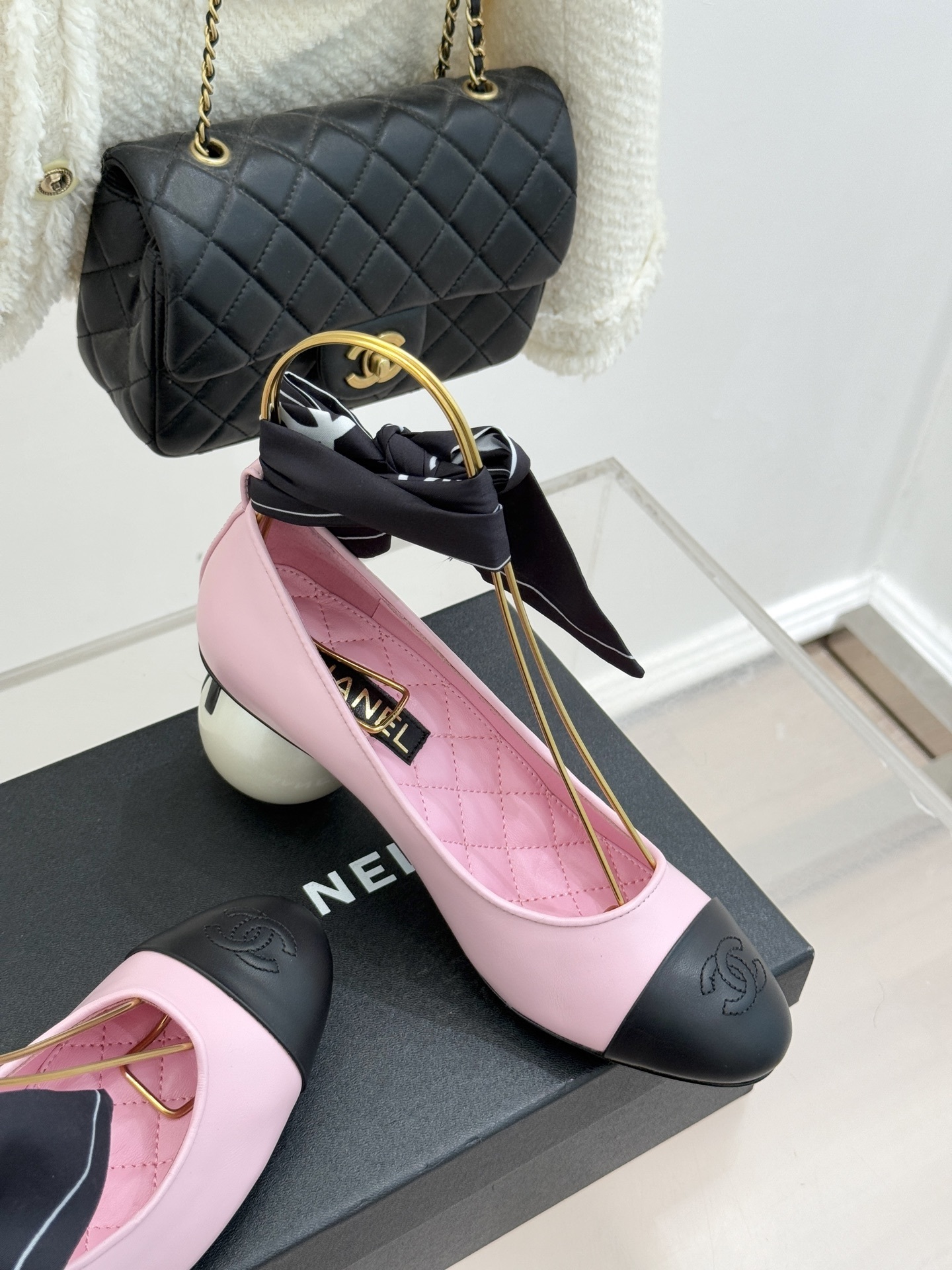 Chanel pink leather pumps with black cap toe and a large white pearl heel, featuring black bow accents on top. - Hình 5