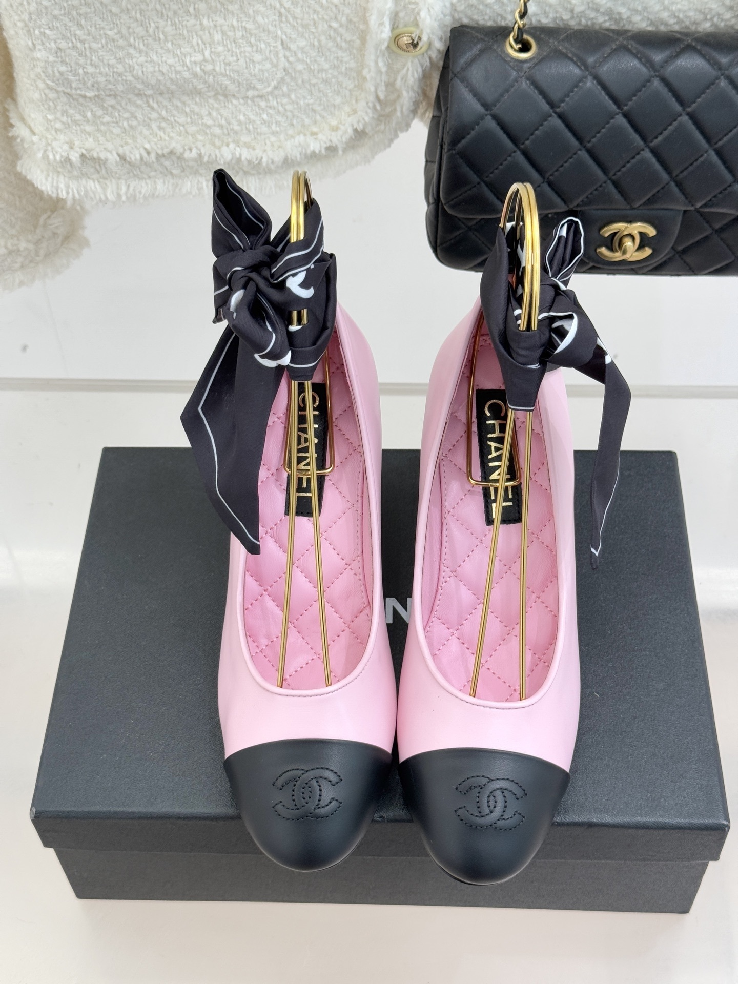 Chanel pink leather pumps with black cap toe and a large white pearl heel, featuring black bow accents on top. - Hình 4